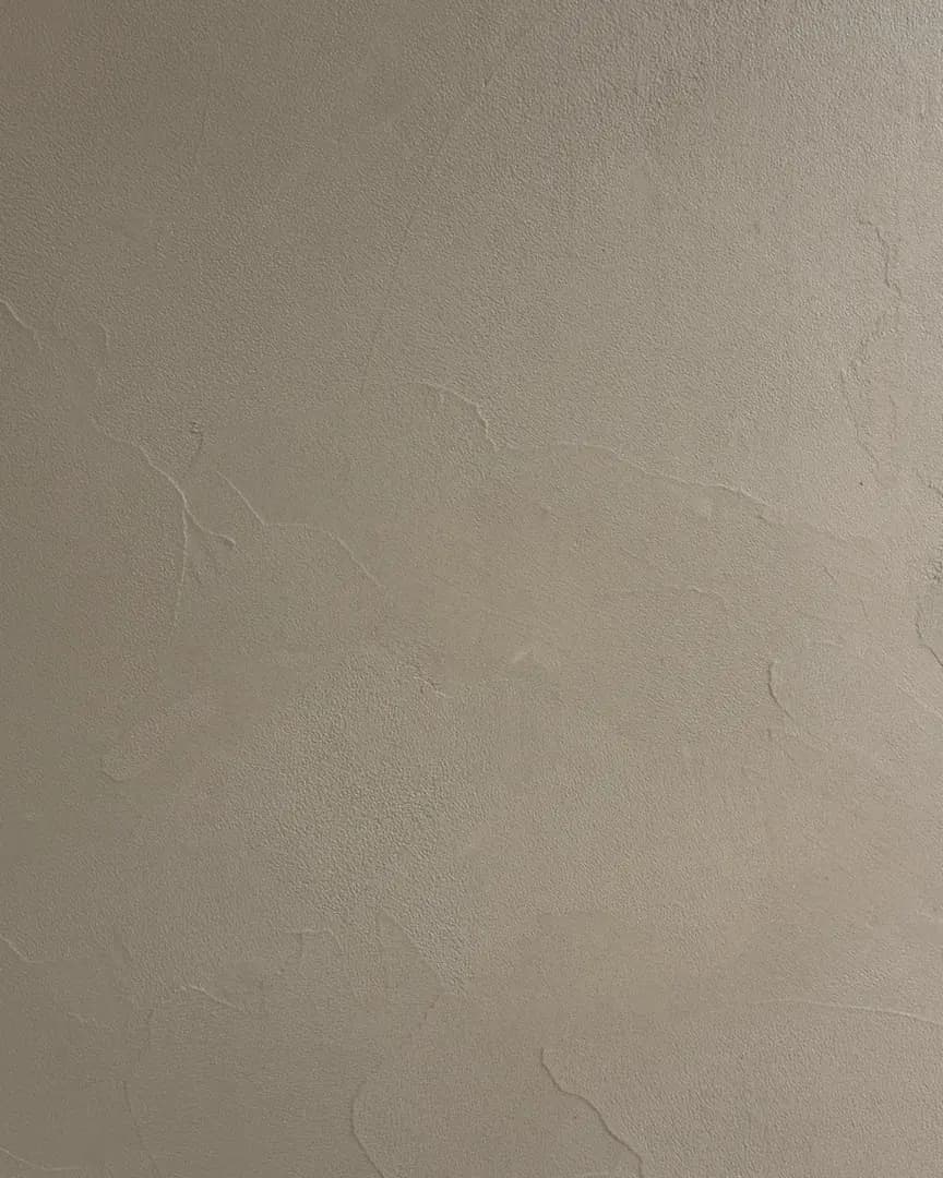 Microcement texture sample in soft warm taupe with a smooth, seamless matte surface.