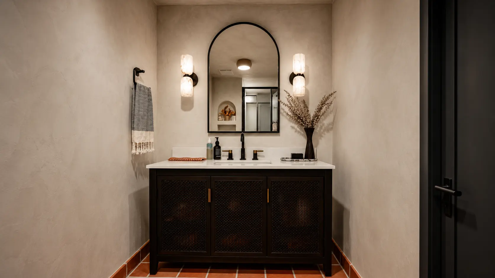 Powder room with lime wash walls, a dark vanity and terracotta floor tiles