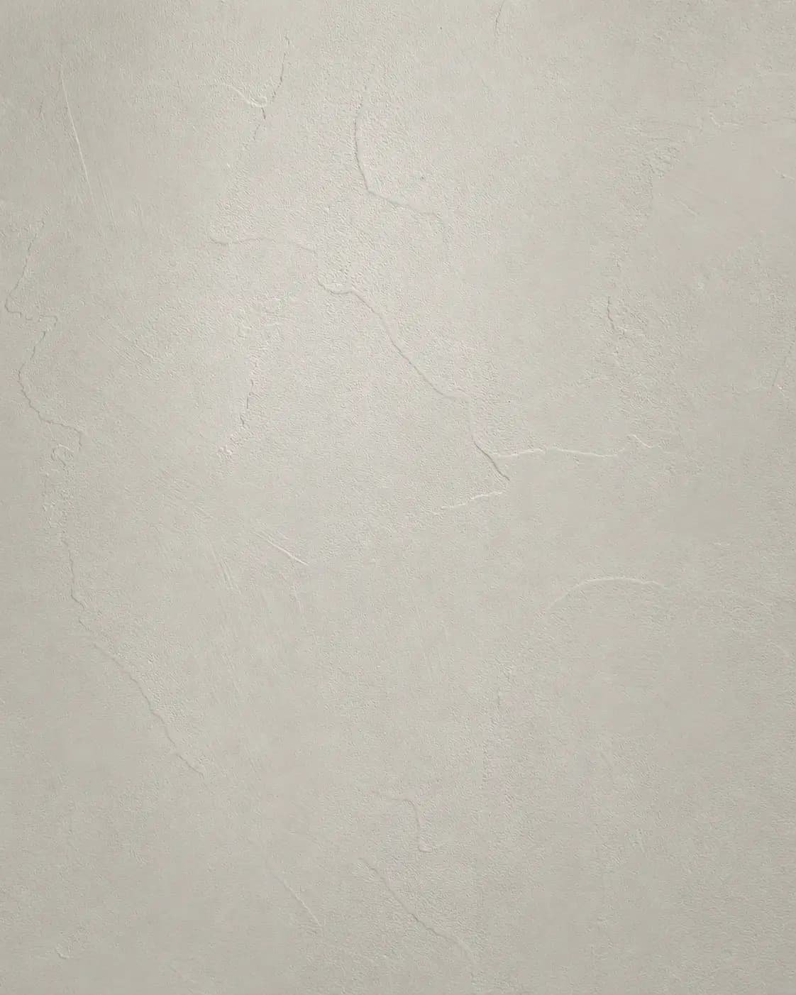 Microcement texture sample in soft pale gray with a smooth, seamless matte surface.